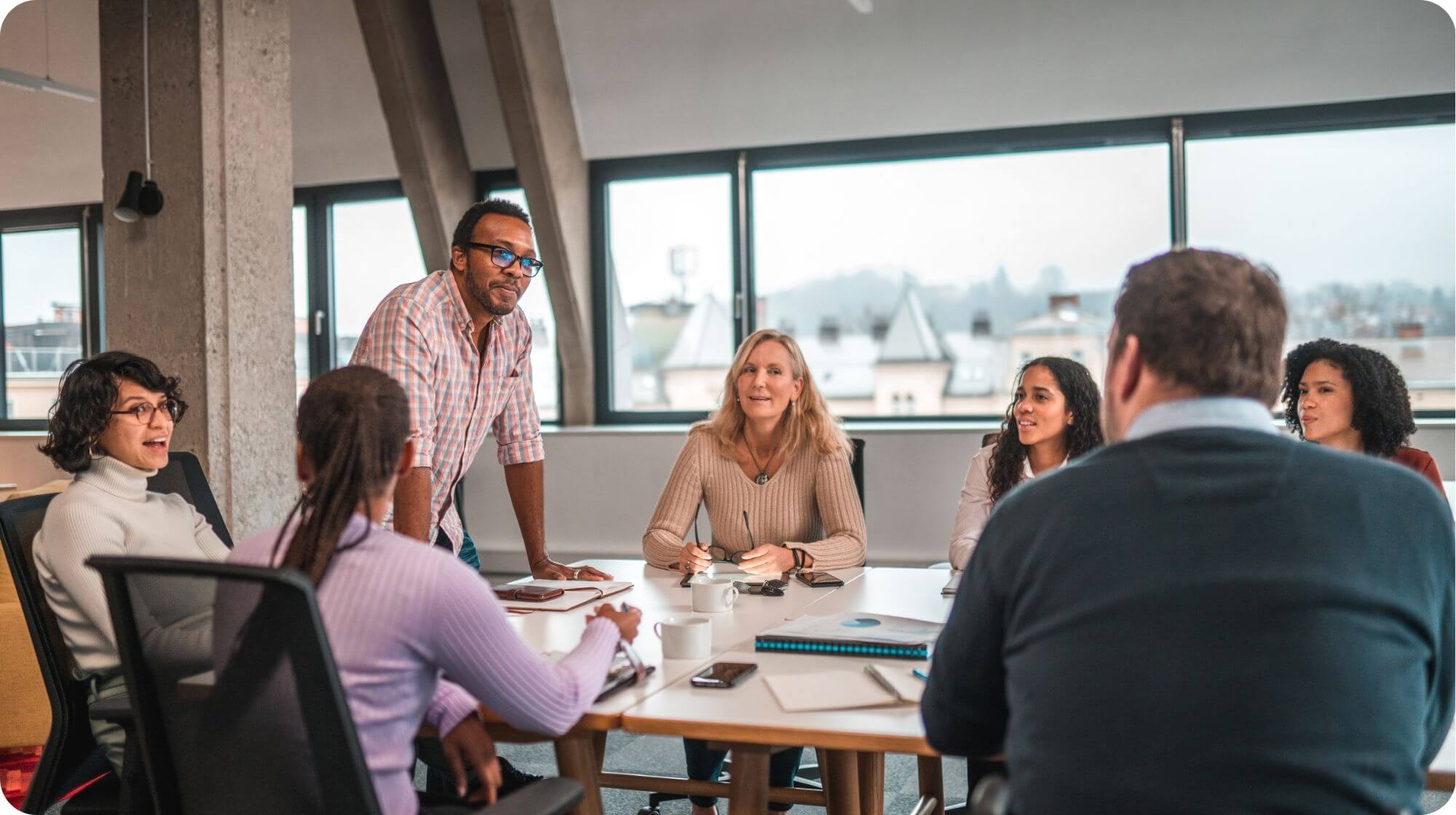 A group of people are meeting around a table. They appear to be in discussion.