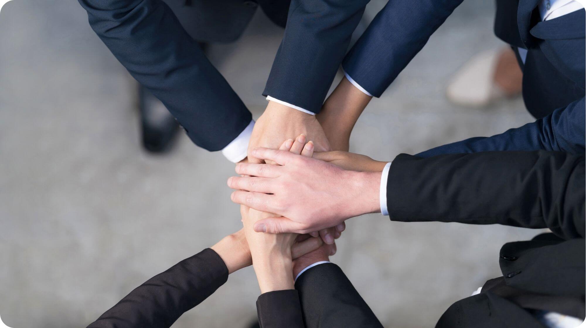 This image depicts teamwork with people's hands stacked on top of each other.